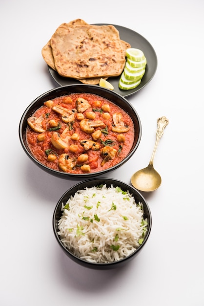 Mushroom sabzi in tomato curry with chickpea and spinach, Indian main course menu served with Paratha and cooked white rice