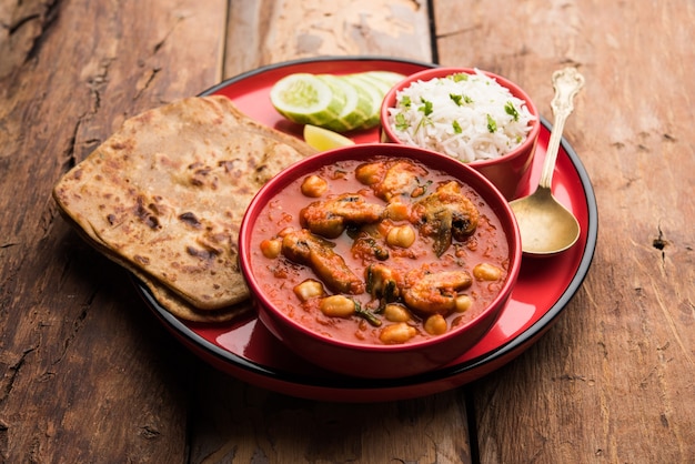 Mushroom sabzi in tomato curry with chickpea and spinach, Indian main course menu served with Paratha and cooked white rice