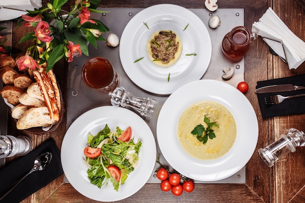 Грибной суп, салат и картофельное пюре на деревянном столе