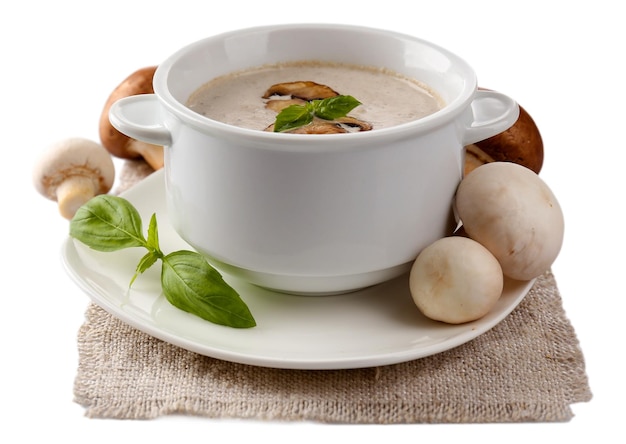 白で隔離されるナプキンに白いボウルにキノコのスープ
