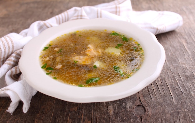 Foto zuppa di funghi con pollo e orzo. decorato con verde. su un vecchio fondo di legno.