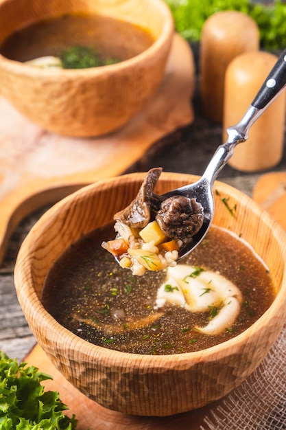 Mushroom soup in a wooden bowl with sour cream