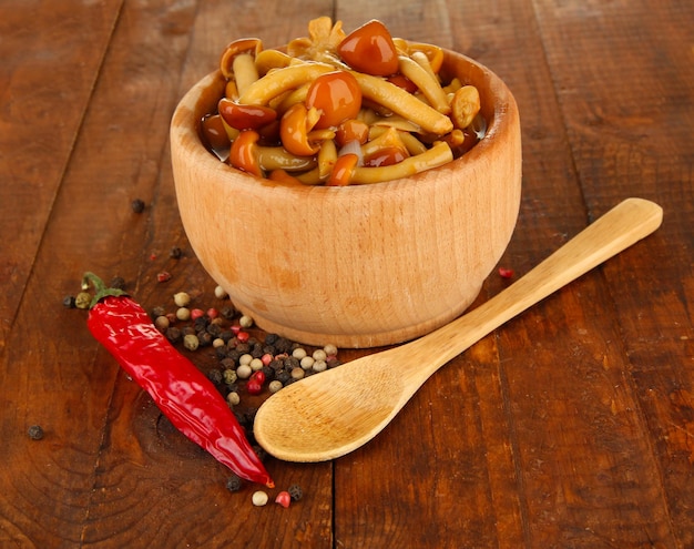 Mushrooms in bowl on wooden background