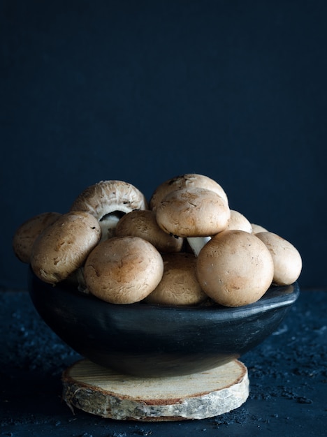 Mushrooms in bowl on wooden board