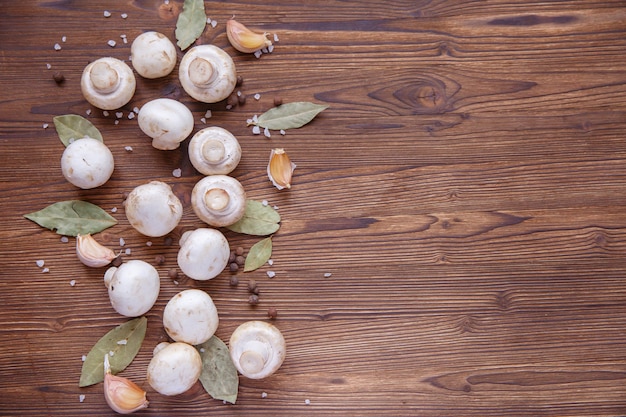 Foto funghi funghi e ingredienti su uno sfondo di legno. spazio per il testo, sfondo per il menu