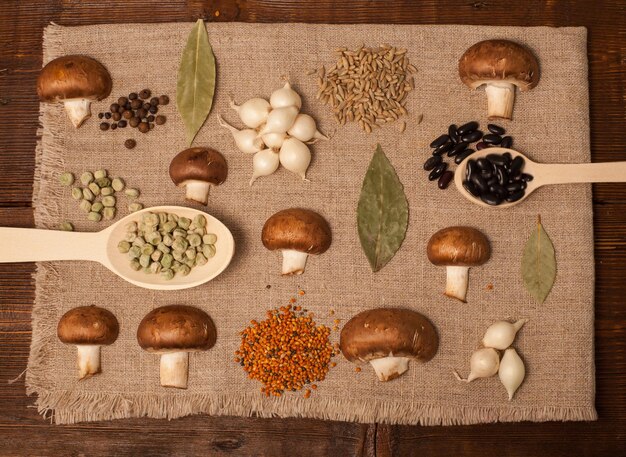 Mushrooms onion and grains in spoons are on a napkin on the table