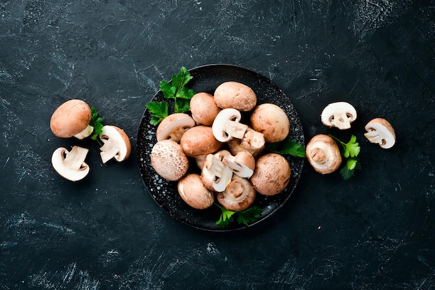 Mushrooms in a plate Champignons on the old background Top view Free copy space