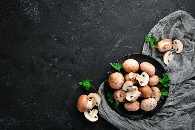 Mushrooms in a plate Champignons on the old background Top view Free copy space