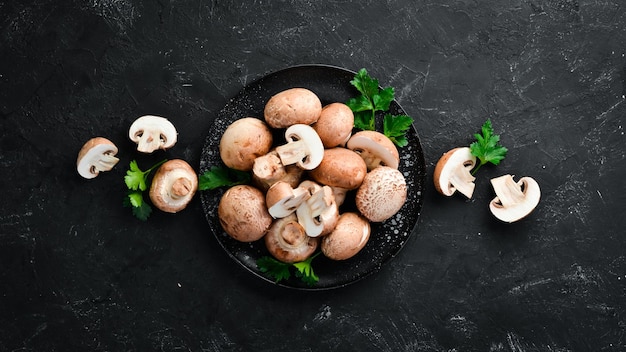Mushrooms in a plate Champignons on the old background Top view Free copy space