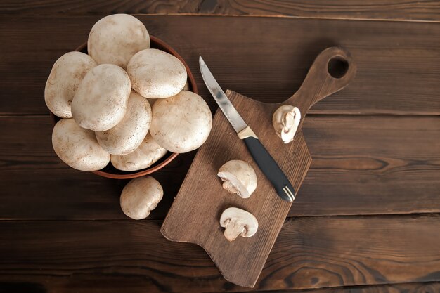 Photo mushrooms in a plate on a dark wooden board