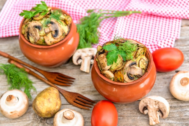 Mushrooms and potatoes cooked in clay pots in the oven.