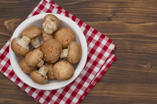 Mushrooms in white plate on brown wooden table