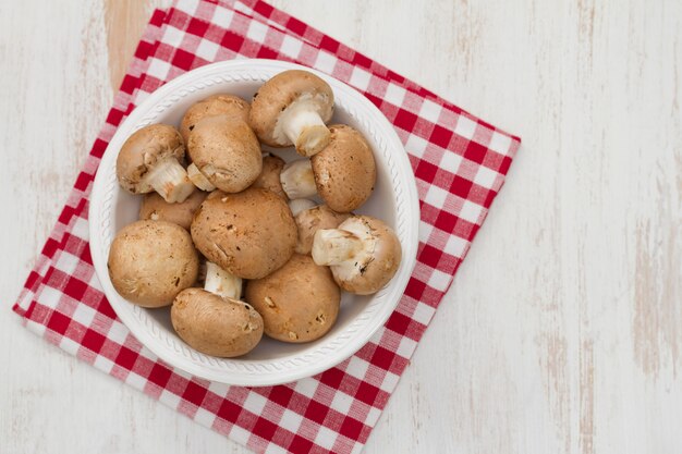 Mushrooms in white plate on white wooden table