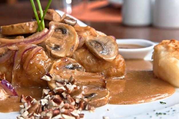 Mushrooms with chicken in red sauce and walnut pieces Peruvian food gastronomy