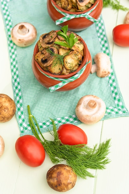 Mushrooms with potatoes and meat cooked in a clay pot in a stone oven. In nature.