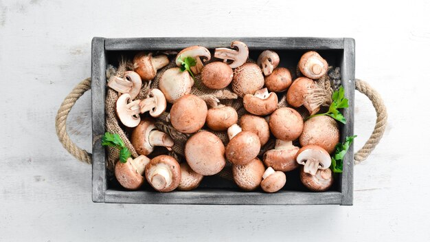 Mushrooms in a wooden box on the old table Champignons Top view Free copy space
