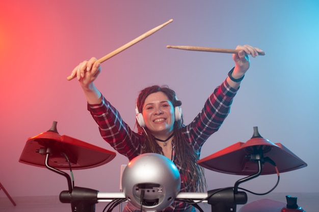 음악과 취미 개념-전자 드럼 세트를 연주하는 여자 드러머