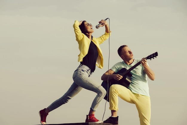 Music band of man and woman with guitar and microphone