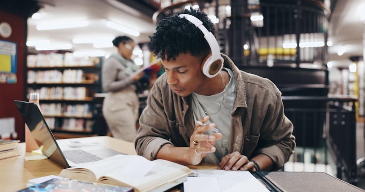 Photo music book and research with man in library for knowledge education and college thesis headphones future and university with student and studying on campus for exam project and scholarship