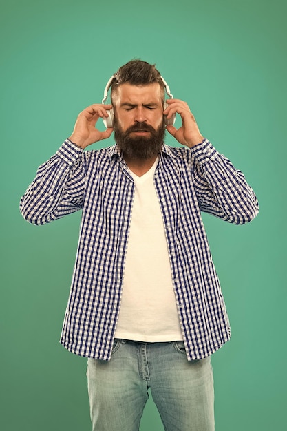 Photo music brutal caucasian hipster with moustache happy man hipster listen to music bearded man hair and beard care man in earphones young and brutal mature hipster with beard e book education