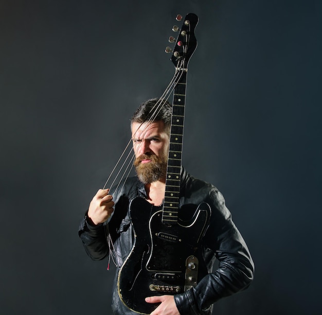 Music concept bearded man with electric guitar guitarist with bass guitar musician holds electric