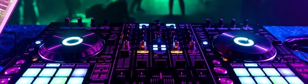 ダンスフロアの背景にあるブースの音楽コントローラーDJ