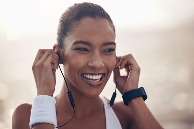 Music fitness and exercise with a woman runner streaming audio while outdoor for training or workout Running sports and health with a female athlete listening on earphones during a cardio run