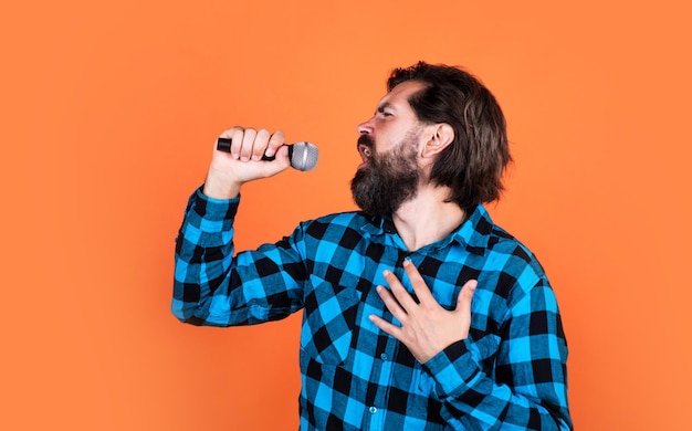 Music is the answer male in karaoke music and vocal concept bearded man in checkered shirt with microphone casual guy country singer hipster with long hair and moustache sing song