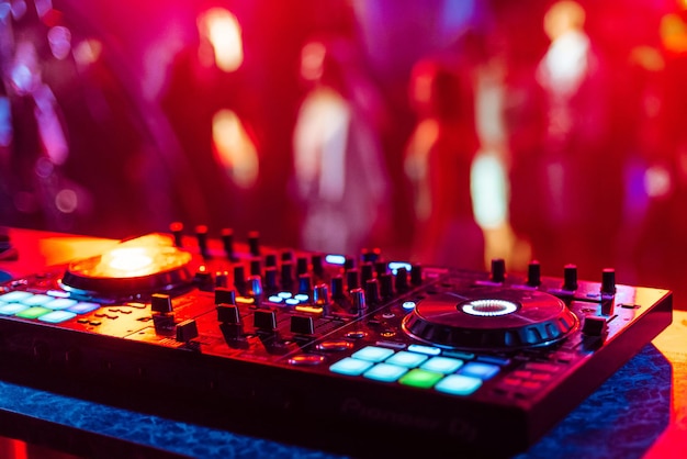 Music mixer DJ controller in booth at nightclub