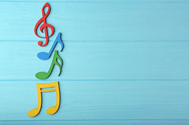 Music notes on color wooden background