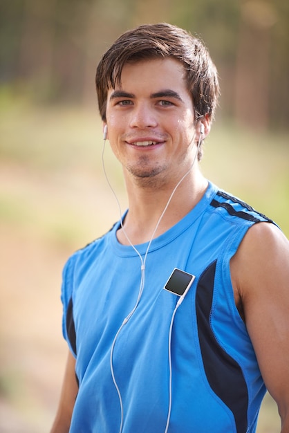 Foto ritratto di un musicista o di un uomo felice che corre con le cuffie durante un esercizio all'aperto o un allenamento di fitness corridore natura o atleta che ascolta una playlist per lo streaming di podcast radio o allenamento sportivo