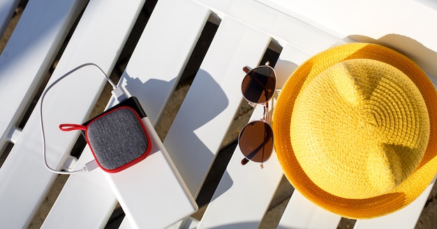 L'altoparlante portatile music si ricarica dal power bank tramite usb su una sdraio vicino alla piscina con accessori da spiaggia.