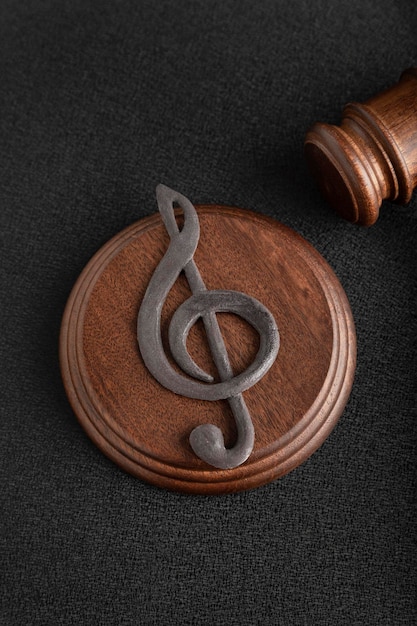 Premium Photo | Music symbol treble clef and judge gavel on black background.  music piracy and copyright infringement. vertical frame.