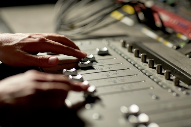 Photo music, technology, people and equipment concept - hands using mixing console in sound recording studio