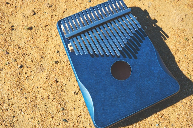 Musical African instrument Kalimba on yellow sand on a bright sunny day.