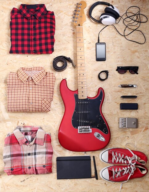 Musical equipment clothes and footwear on wooden background