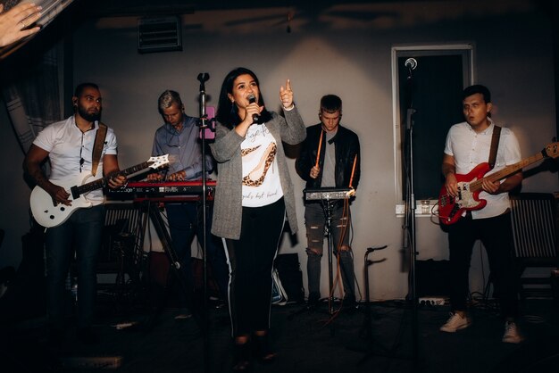 Musical group, band, on stage in bright rays