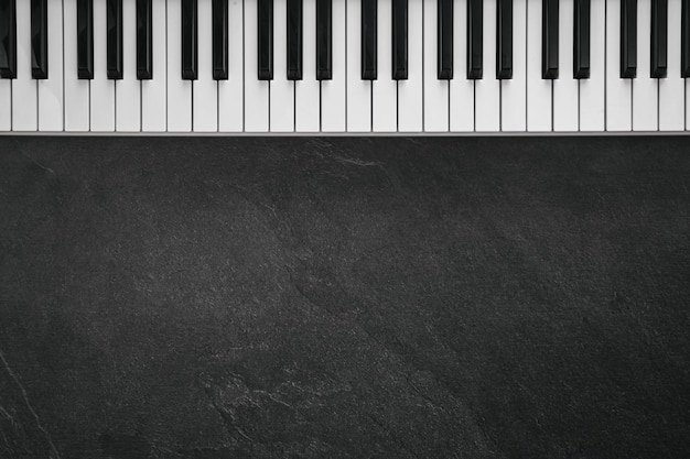 Photo musical keyboard on a textured black background flat lay copy space