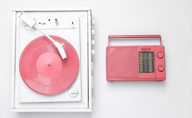 音楽レイアウト白いビニール レコード プレーヤーと白い背景の上のピンクのクールなラジオ受信機トップ ビュー フラット レイアウト