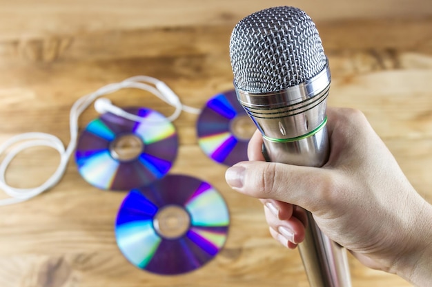 Musical microphone in hand with DVD discs