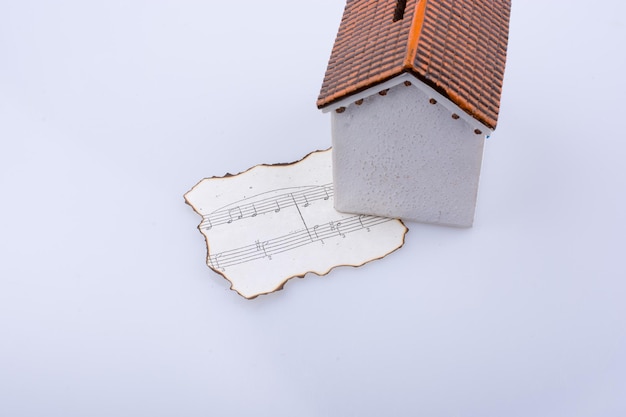 Musical notes on a burnt paper under a model house