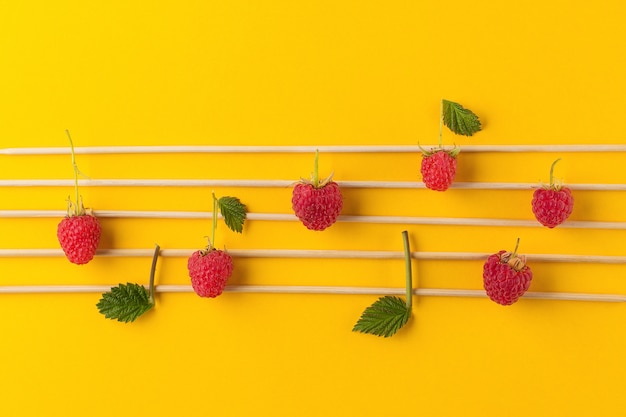 Musical notes conception. Wooden musical notes and raspberries