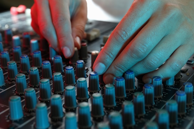 Foto il musicista regola il suono sul mixer audio