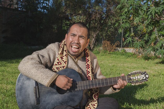 Foto il musicista tiene la chitarra. un ritratto in primo piano di un uomo sacro con abiti tradizionali