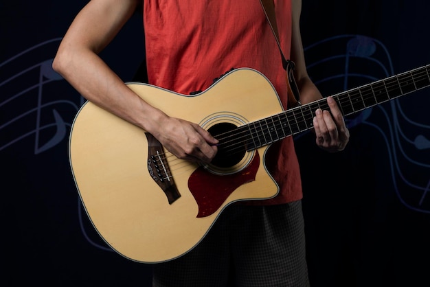 Musicista con una chitarra acustica al buio