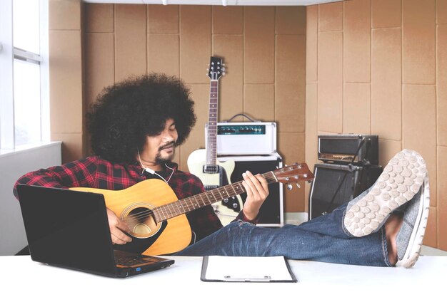 Musician with hands in guitar inside recording studio