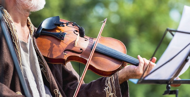 Musician with violin outdoors during concert, panorama