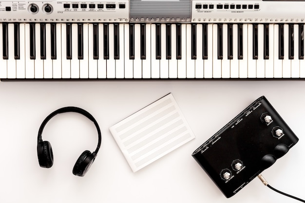 Musician work set with synthesizer, note and headphones