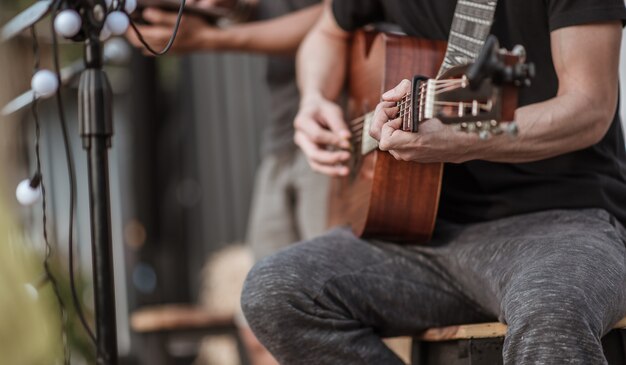 The musicians are checking the sound of the guitar and trying to play the guitar before the event