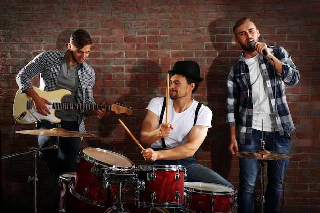 Photo musicians playing the drums on brick wall background